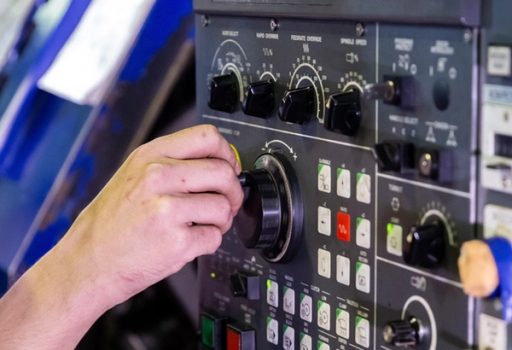 Someone turning a factory dial to adjust settings