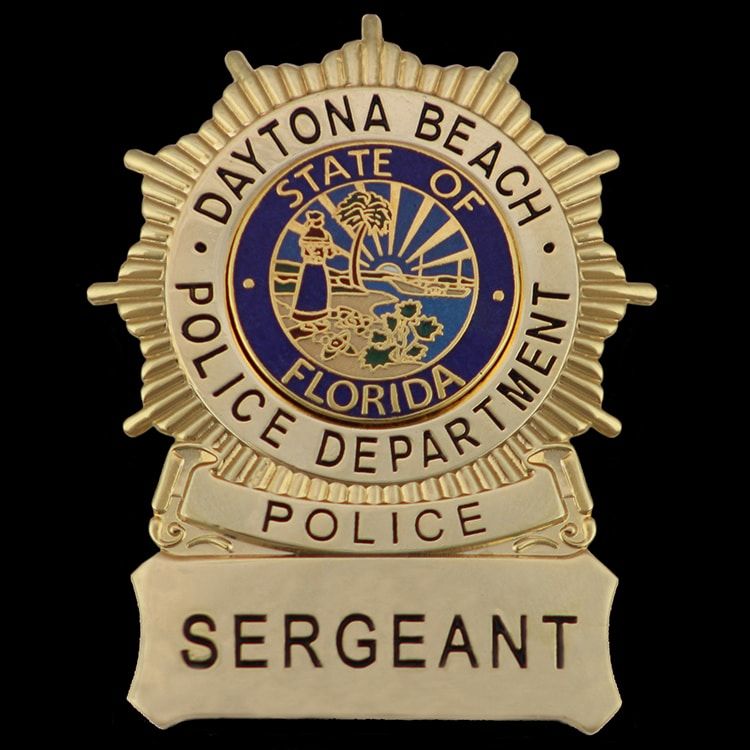 Gold sunburst badge with a full colour seal in blue enamel at the centre and a rank bar across the bottom.
