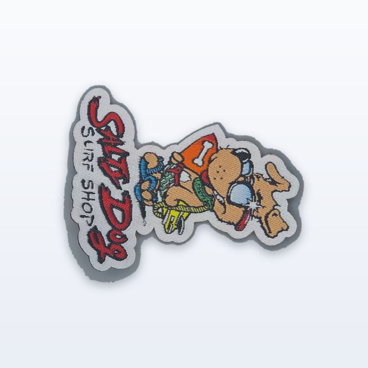Woven Salt Dog Surf Shop patch with red lettering and a cartoon dog, cut to the outline of the design instead of a stitched border.