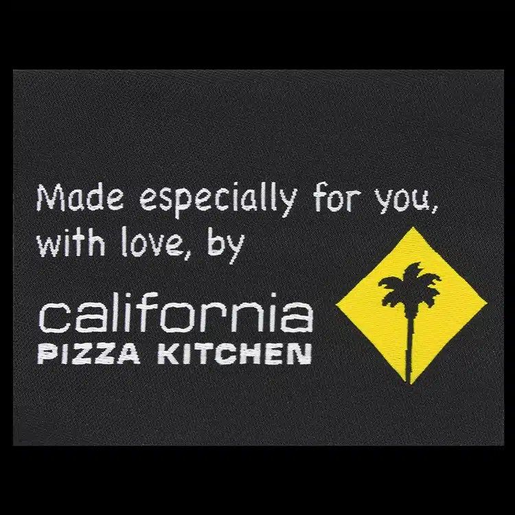 California Pizza Kitchen woven label reading Made especially for you, with love, white and yellow lettering on black.