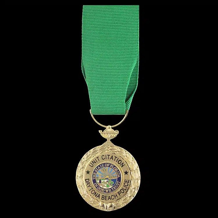 Gold citation medal on a green neck ribbon.