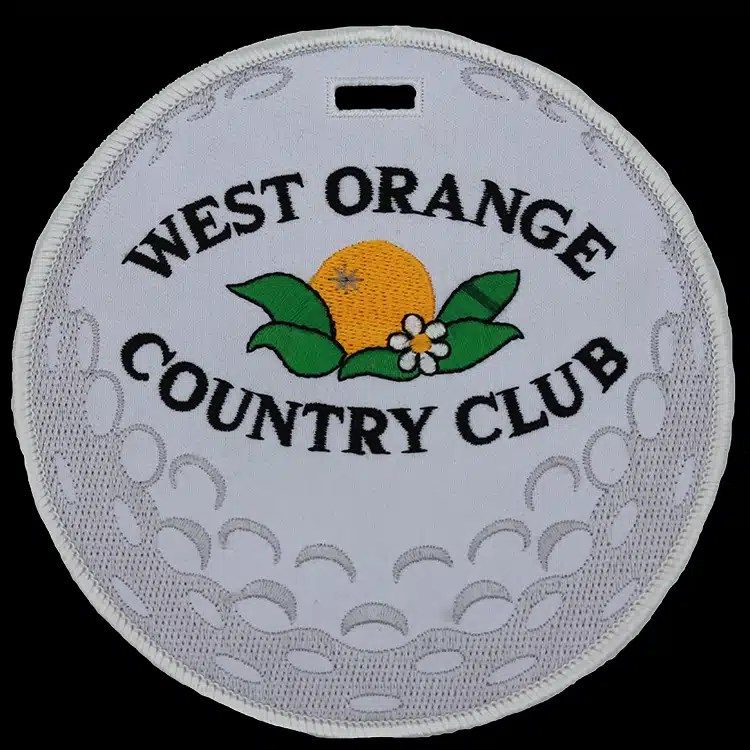 Round embroidered luggage tag styled as a golf ball for West Orange Country Club, white on white, an example of Patchworks USA's finished work.