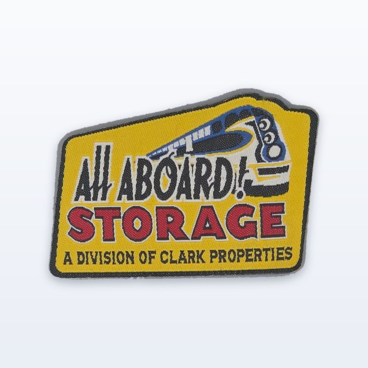 Woven All Aboard Storage patch with a blue and white train above red lettering on a yellow ground.