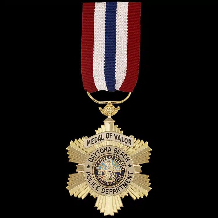 Gold star-shaped medal with a full colour seal at its centre, hanging from a red, white and blue striped drape ribbon.