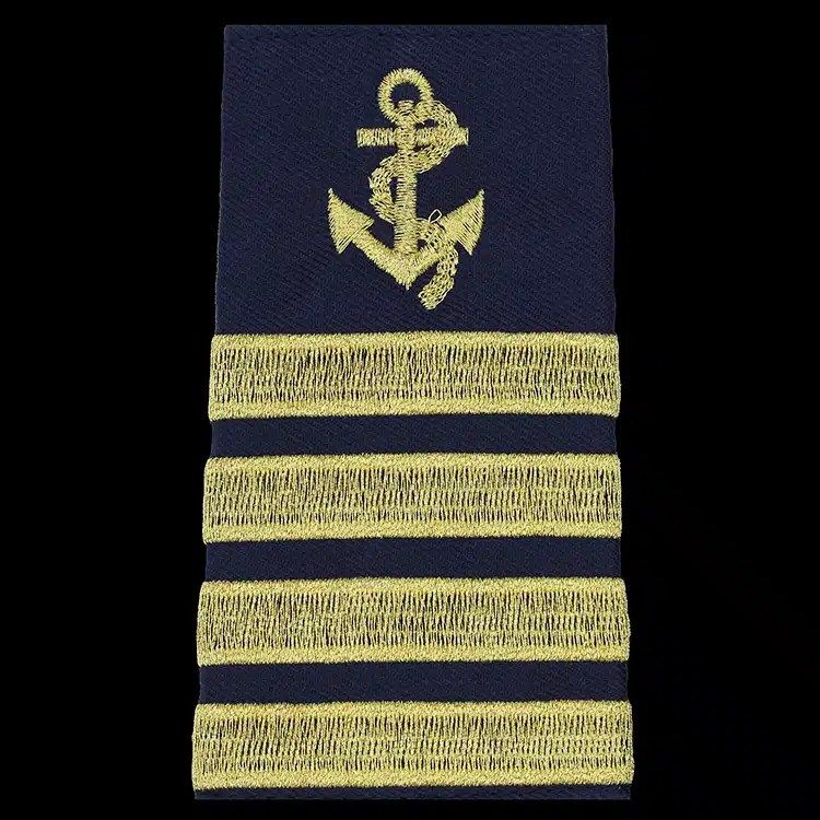 Navy epaulet cover embroidered with a gold metallic thread anchor above four gold braid bars.