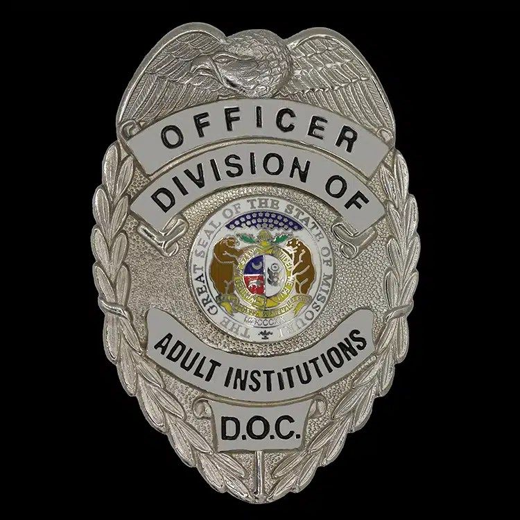 Silver shield-shaped officer badge with an eagle at the center.