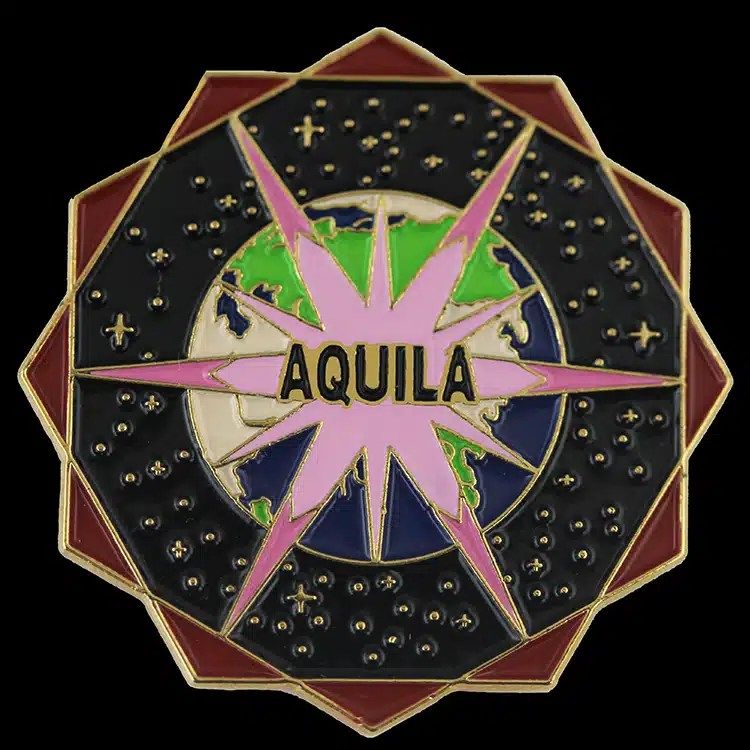 Soft enamel lapel pin in a ten-point star shape with AQUILA across a pink compass star over a globe, the colour set below raised gold metal lines.