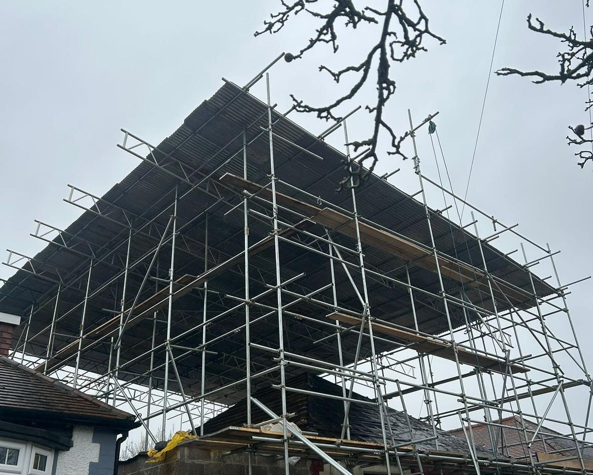Sheeted temporary roof on a scaffold over a house