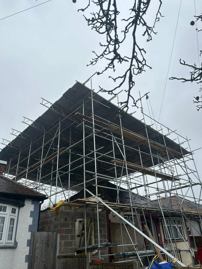 Sheeted temporary roof on a scaffold over a house