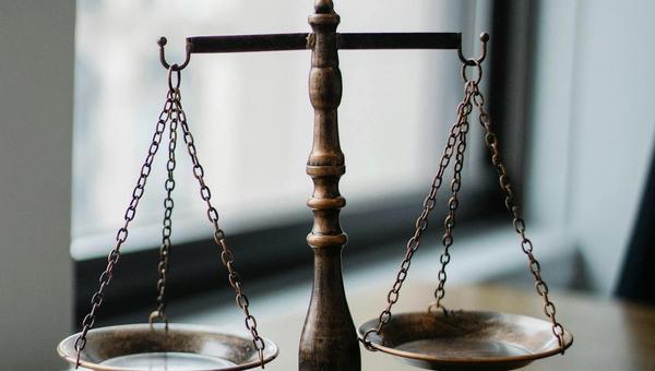 Europaeischer Rechtsanwalt prueft die Kanzlei-Webseite am Laptop im Buero