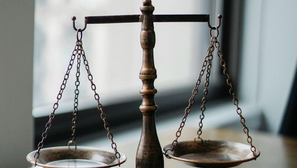 Europaeischer Rechtsanwalt prueft die Kanzlei-Webseite am Laptop im Buero