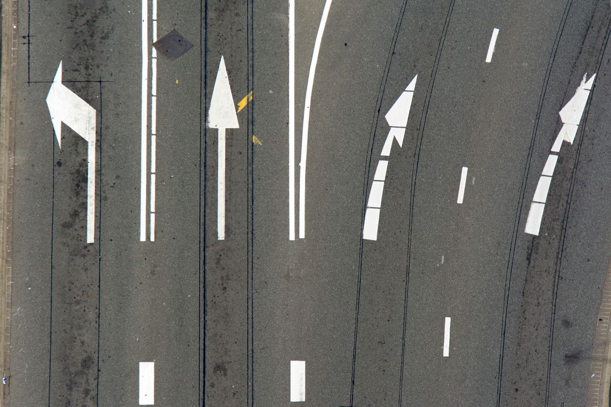 Luftaufnahme von Fahrspuren mit aufgemalten Pfeilen in verschiedene Richtungen
