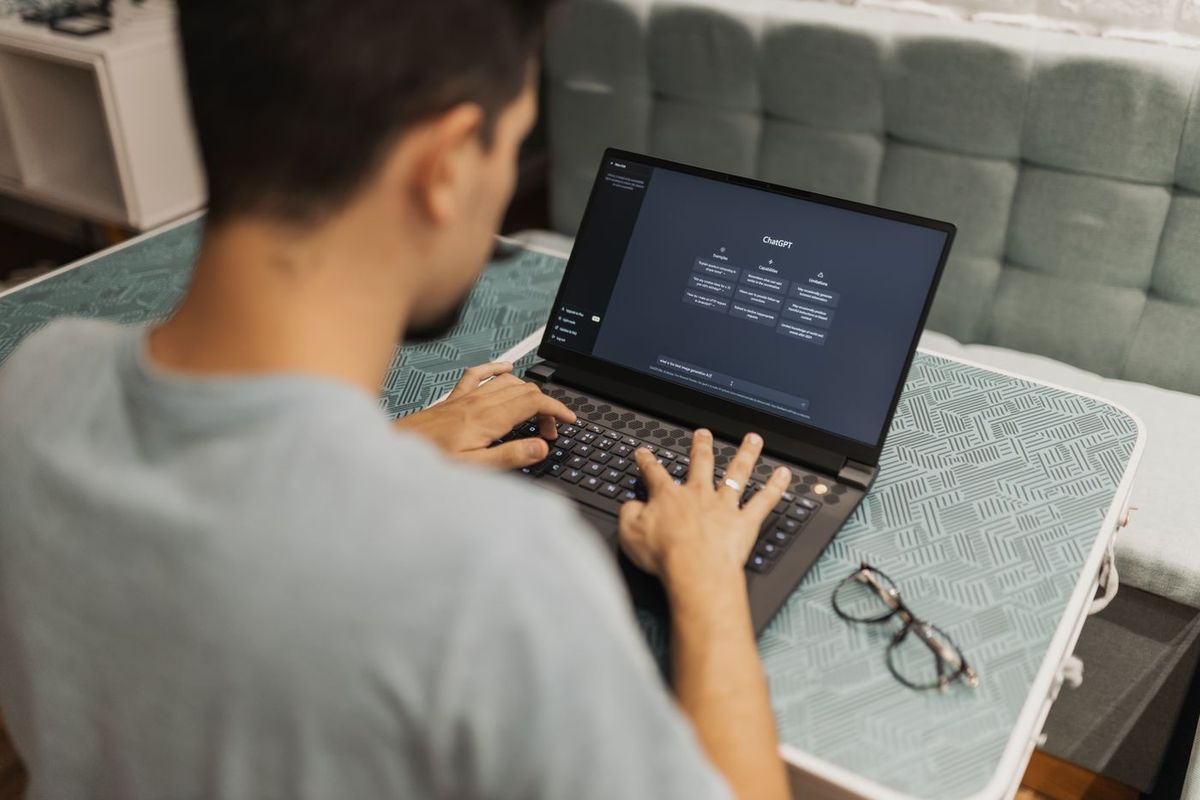 Person typing a question into ChatGPT on a laptop