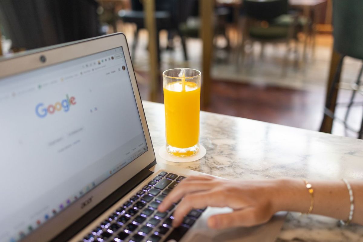 Hand on the keyboard of a laptop open on Google's home page