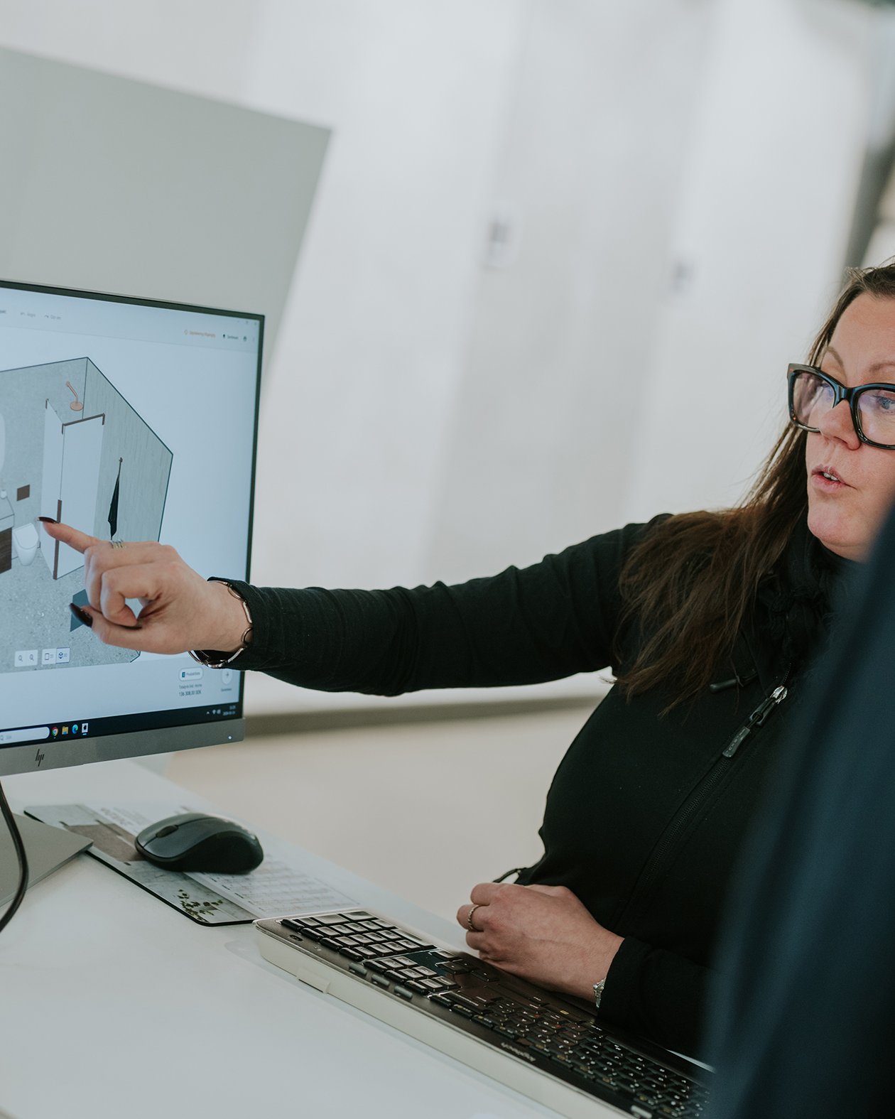 Spark Vision team members reviewing a 3D bathroom design on a computer screen