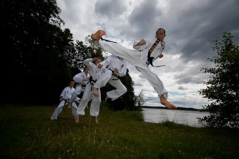 Taekwon-Do-ryhmän potkutekniikoita ulkona, arkistokuva
