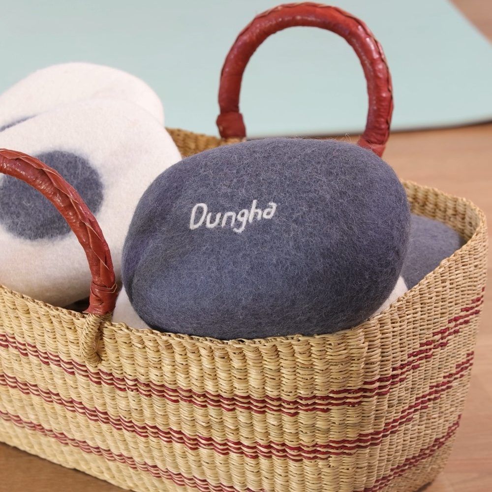 Galets Dungha en feutre gris et blanc dans un panier tressé