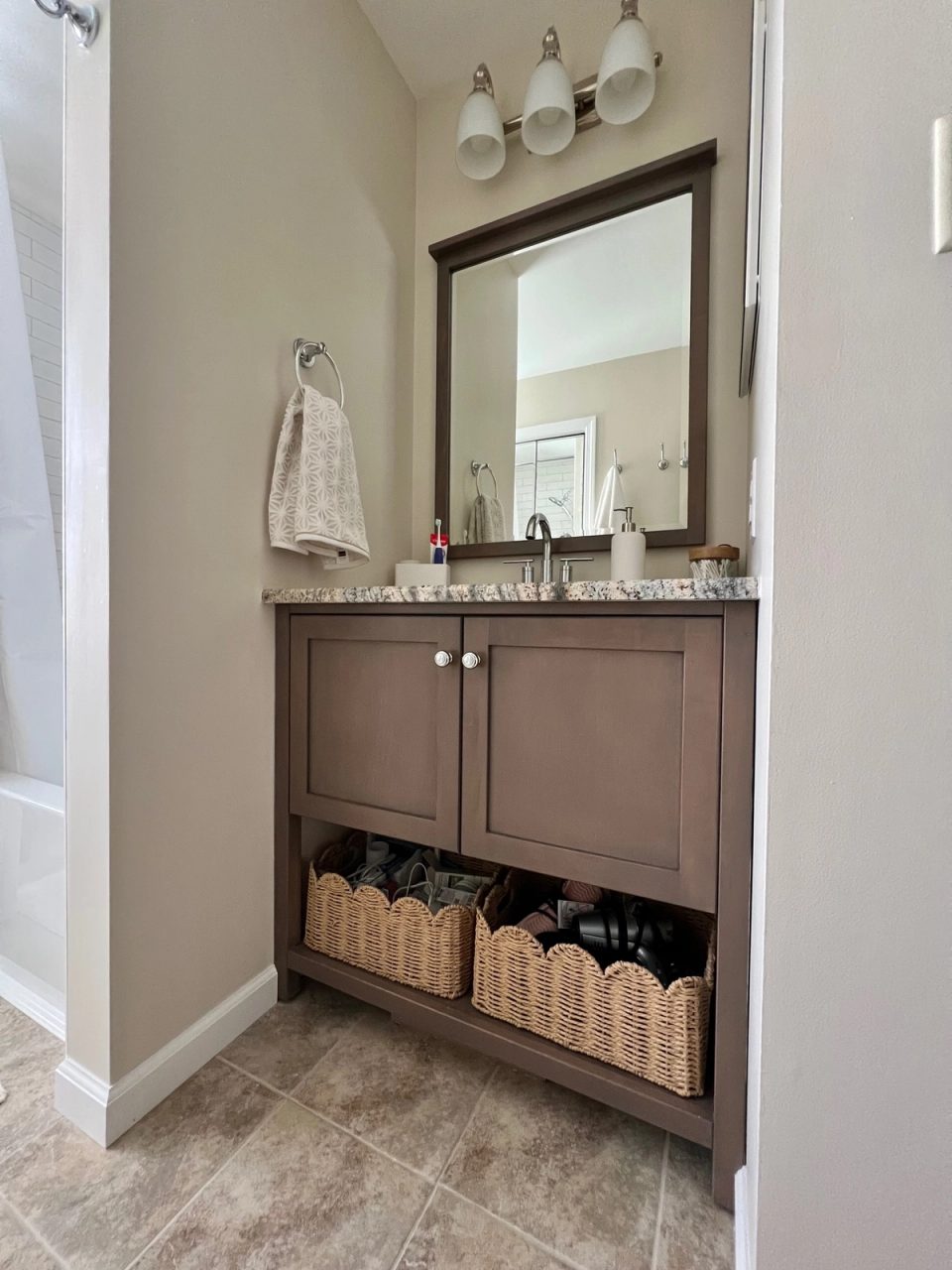 Wood bathroom vanity with a framed mirror and woven storage baskets