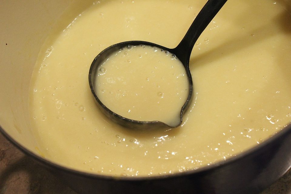 Blended potato leek soup in a pot with a ladle