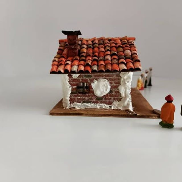 Piccola casetta in mattoncini rossi con comignolo sul tetto
