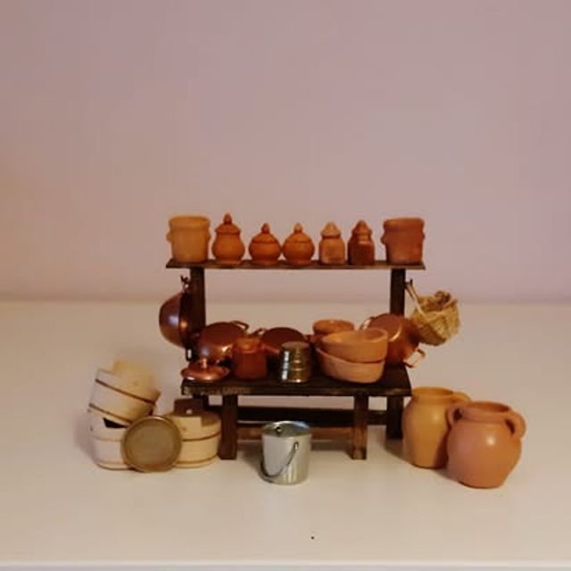 Scaffale con vasetti di terracotta, pentole di rame e botti impilate ai lati