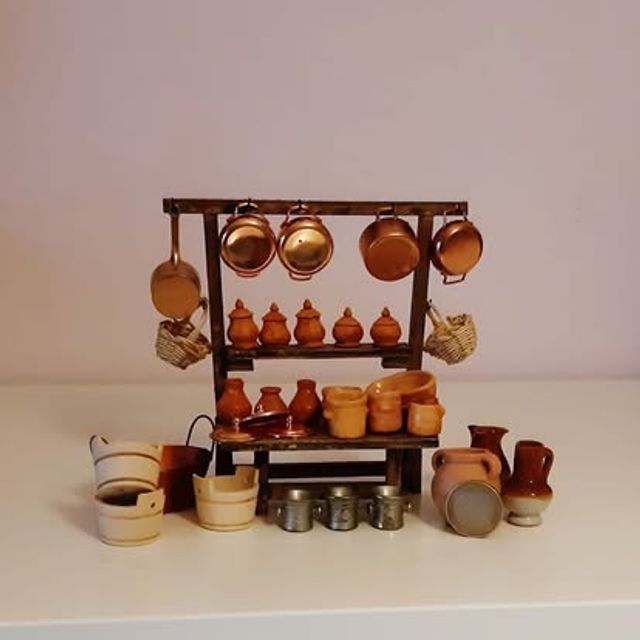 Scaffale con pentole di rame appese, vasetti di terracotta e secchi in legno