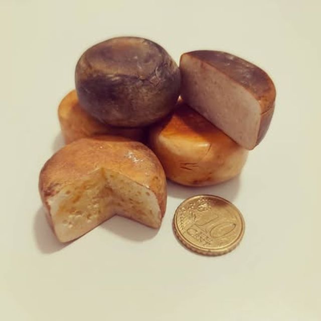 Cinque forme di formaggio sciolte, una tagliata a metà, in miniatura