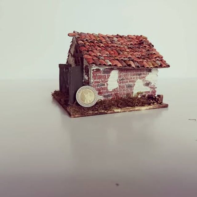 Rudere in miniatura con parete diroccata sul lato sinistro e tetto in coppi