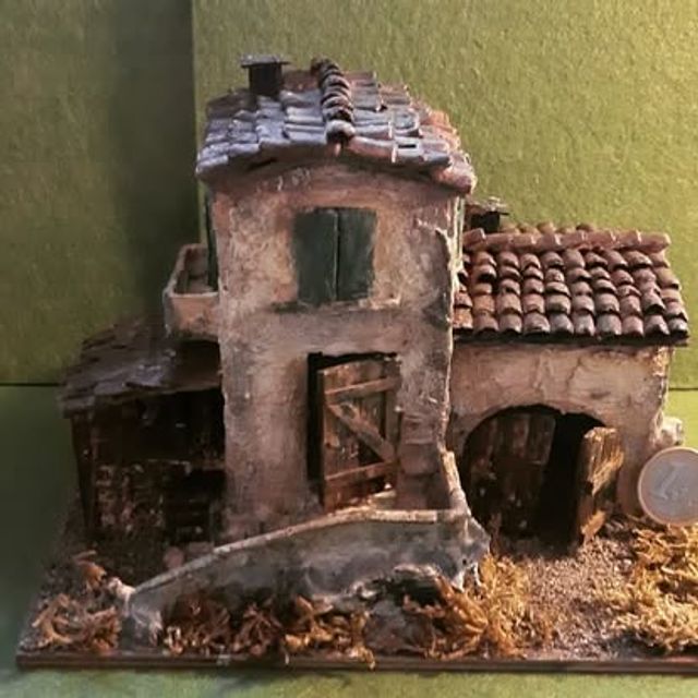 Casa a due piani con portico ad arco al piano terra e balconcino al primo piano