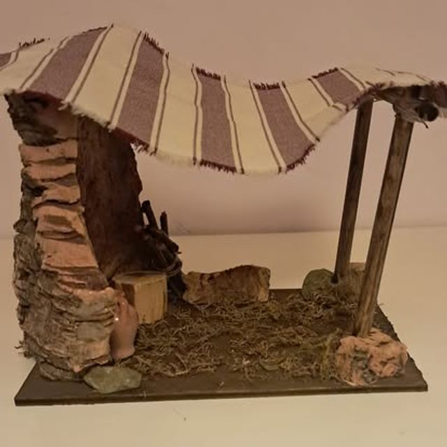 Tettoia in sughero con tenda a righe e un secchio ai piedi della roccia
