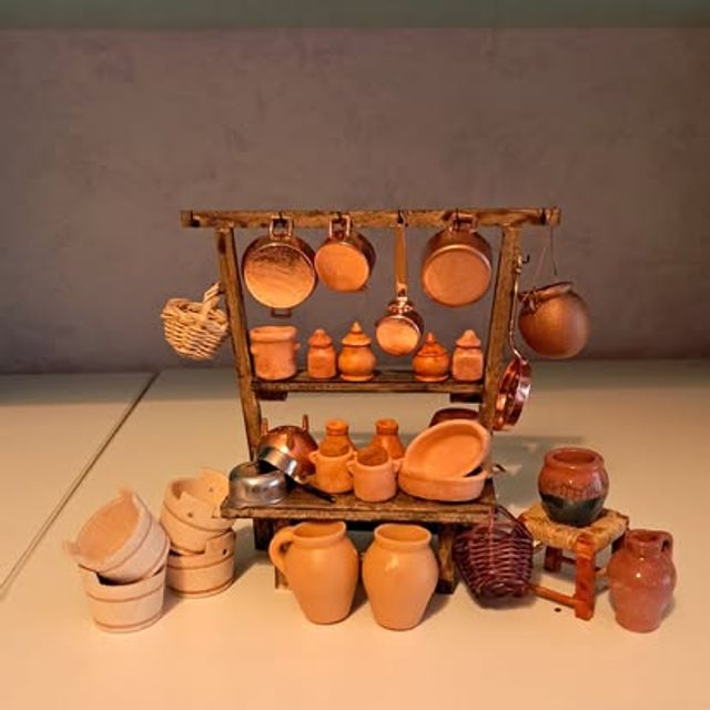 Bancone con pentole appese, brocche di terracotta e cesti sui lati