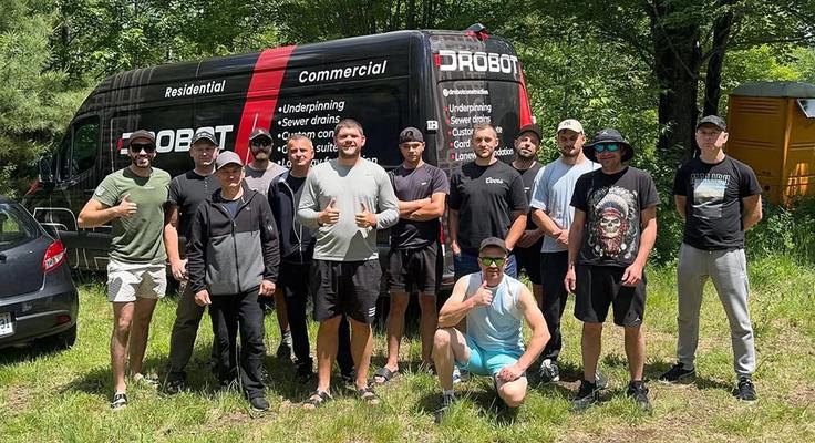 The Drobot Construction crew standing in front of a branded work van