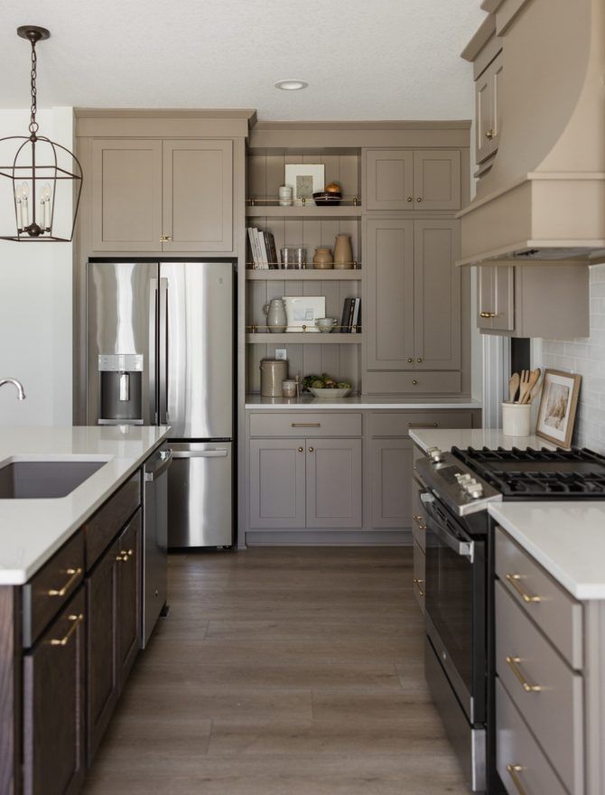 A finished kitchen with a stainless steel refrigerator and pale cabinetry