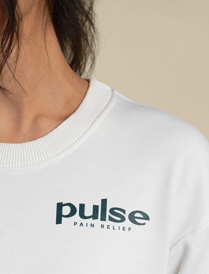 A close-up of a cream sweatshirt printed with the Pulse Pain Relief logo