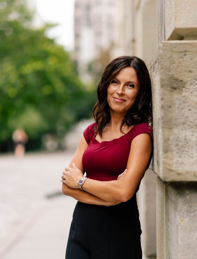 A lawyer standing against a stone wall outdoors