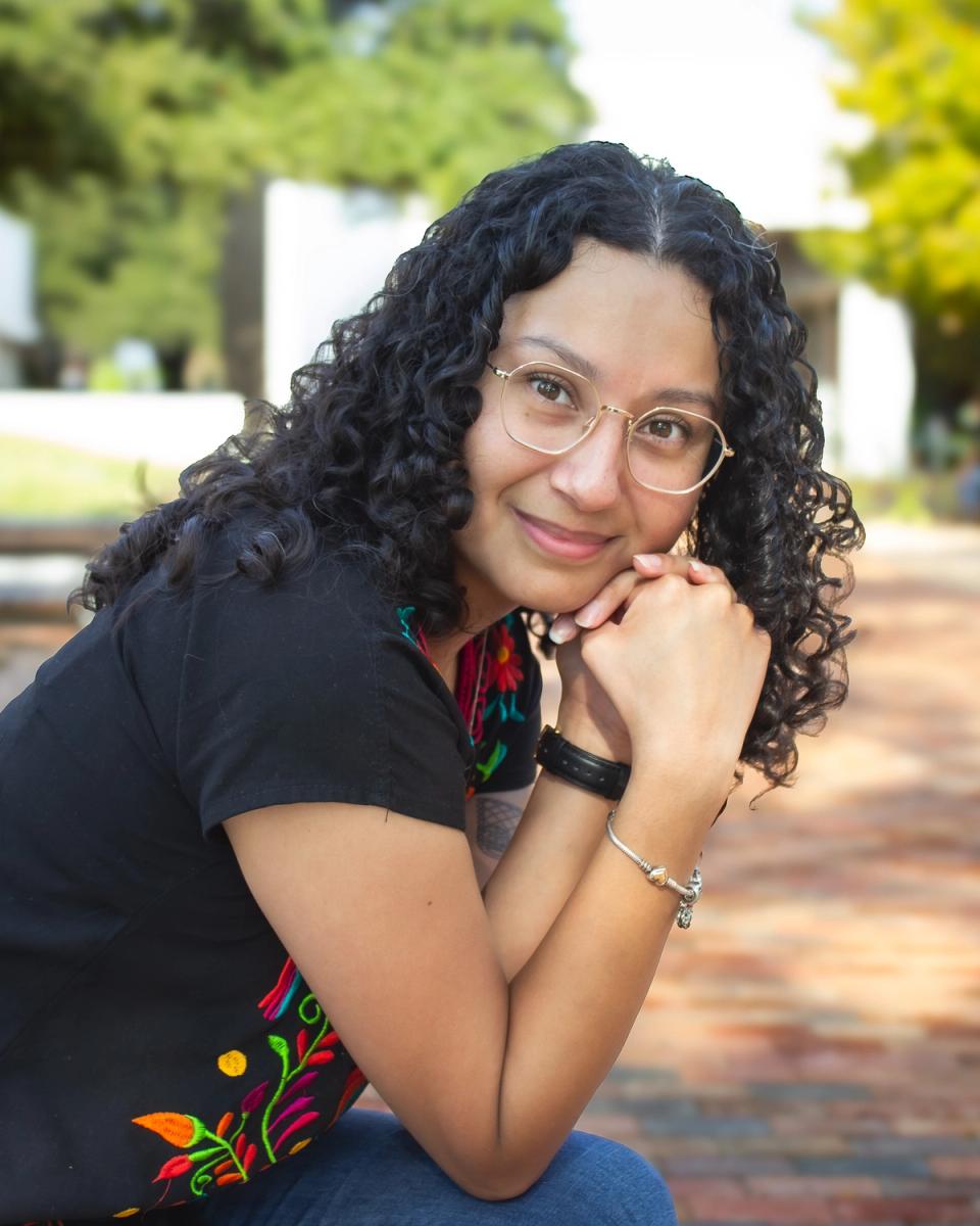 Priscilla Dominguez smiling warmly outside, wearing an embroidered top