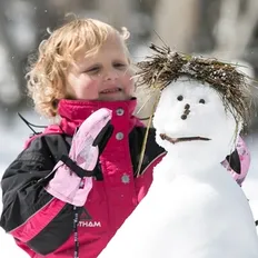 Make A Wish Australia Children's Charity - Isla on her wish in the snow with a snowman