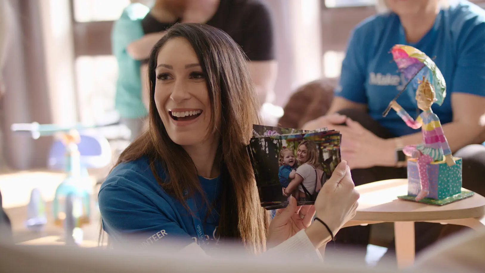 Smiling woman holds photo of wish child