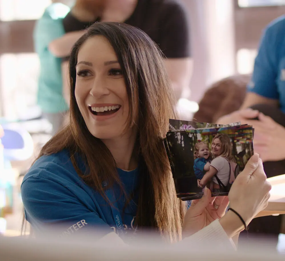 Smiling woman holds photo of wish child
