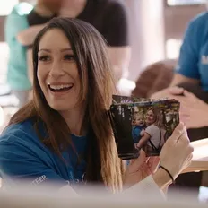 Smiling woman holds photo of wish child