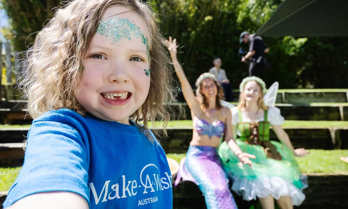 Make A Wish Australia Children's Charity - Female volunteers kneeling down with a wish kid
