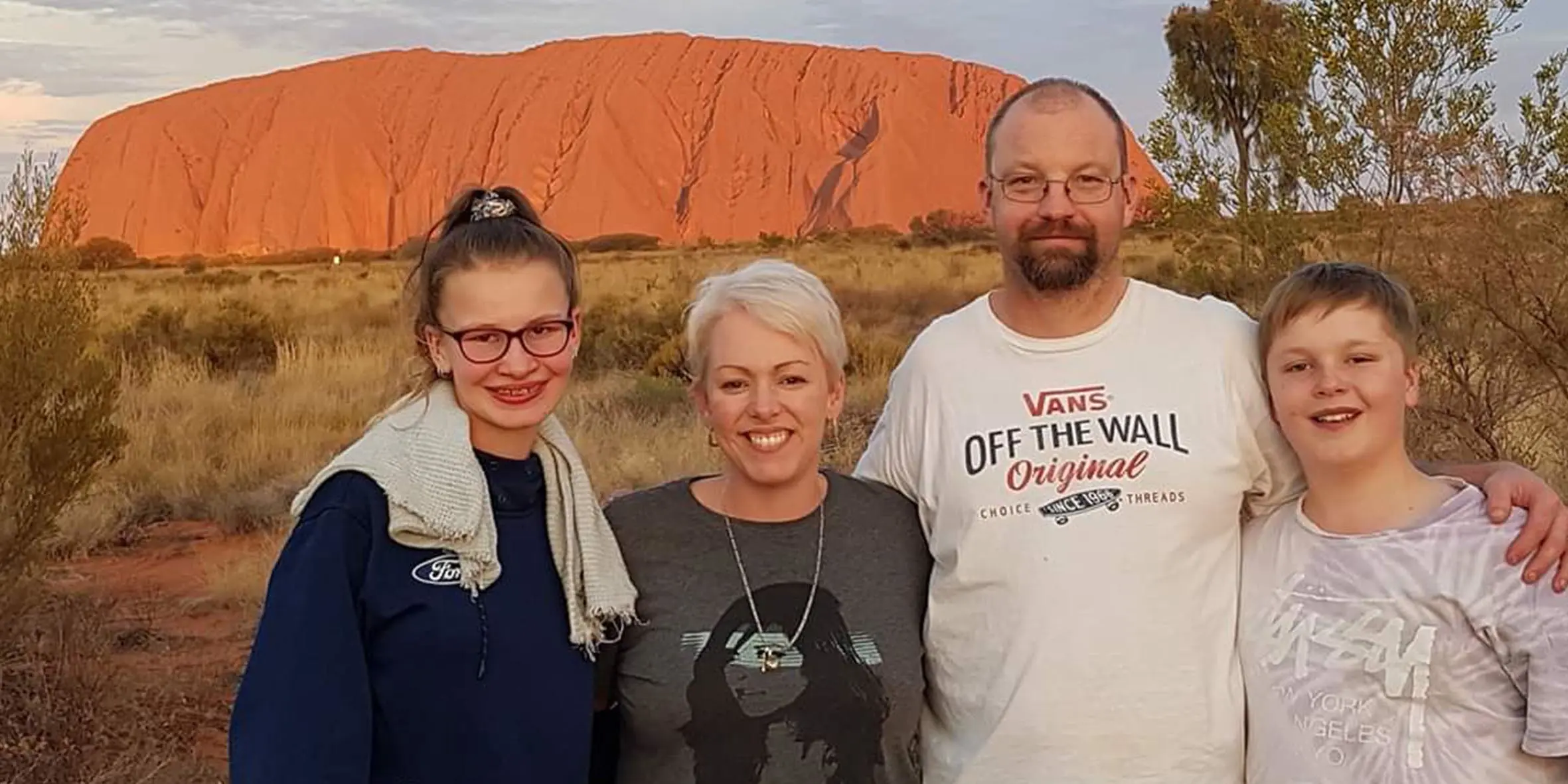 James and family standing in front of Uluru