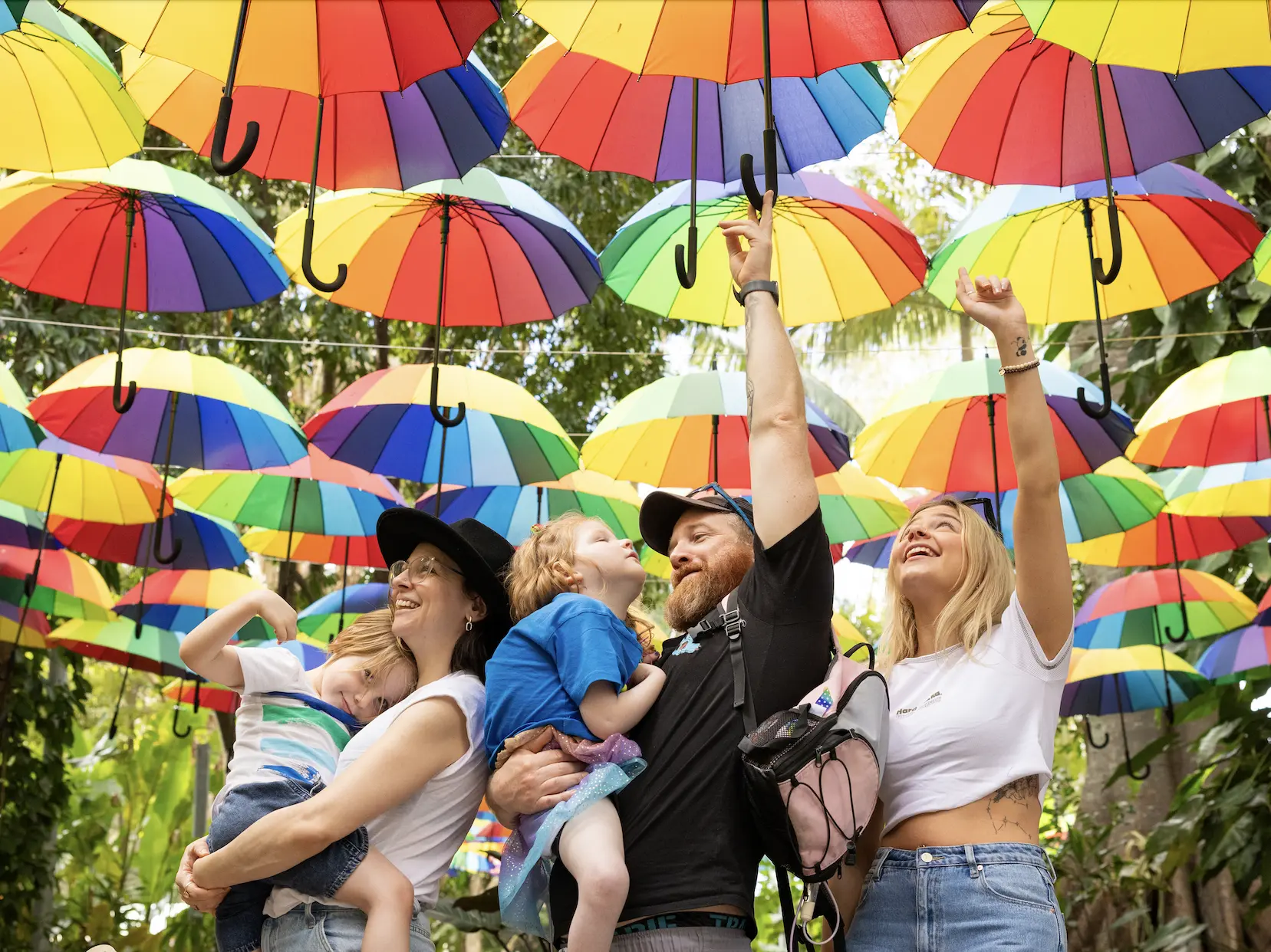 Wish child Roxy and her family reaching for rainbow umbrellas