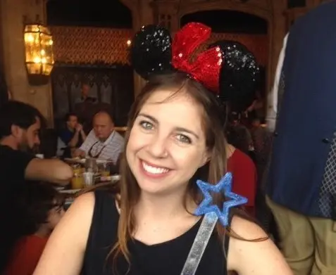 Smiling woman with Mickey ears and a wand
