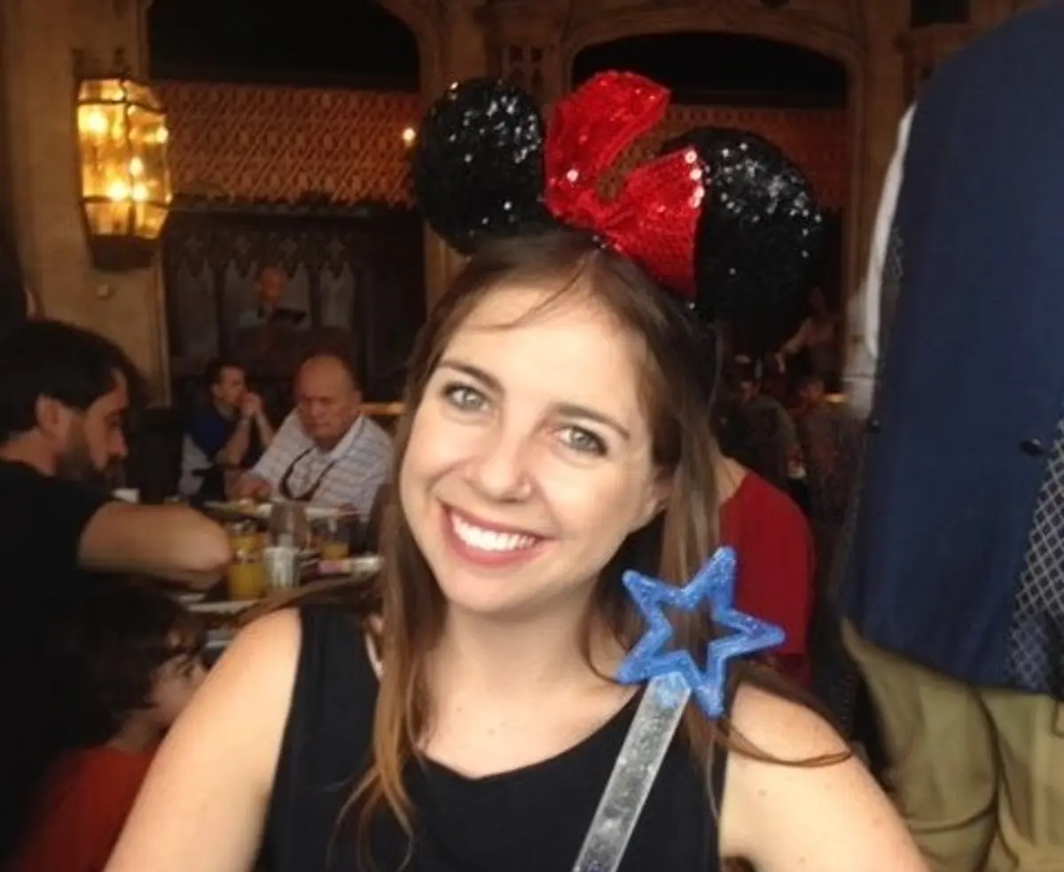 Smiling woman with Mickey ears and a wand