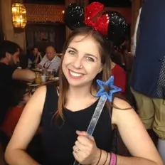 Smiling woman with Mickey ears and a wand