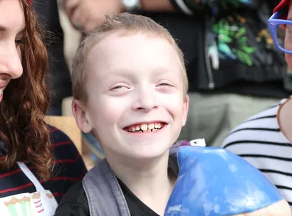 Wishes at Make A Wish Australia Children's Charity - Noah on his wish in the garden with volunteers and a knome