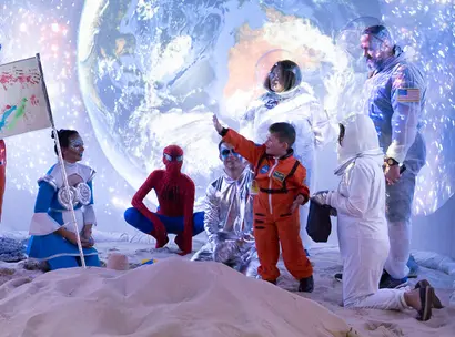 Make-A-Wish Australia wish kid Dwayne wearing his NASA spacesuit on the moon with other space characters