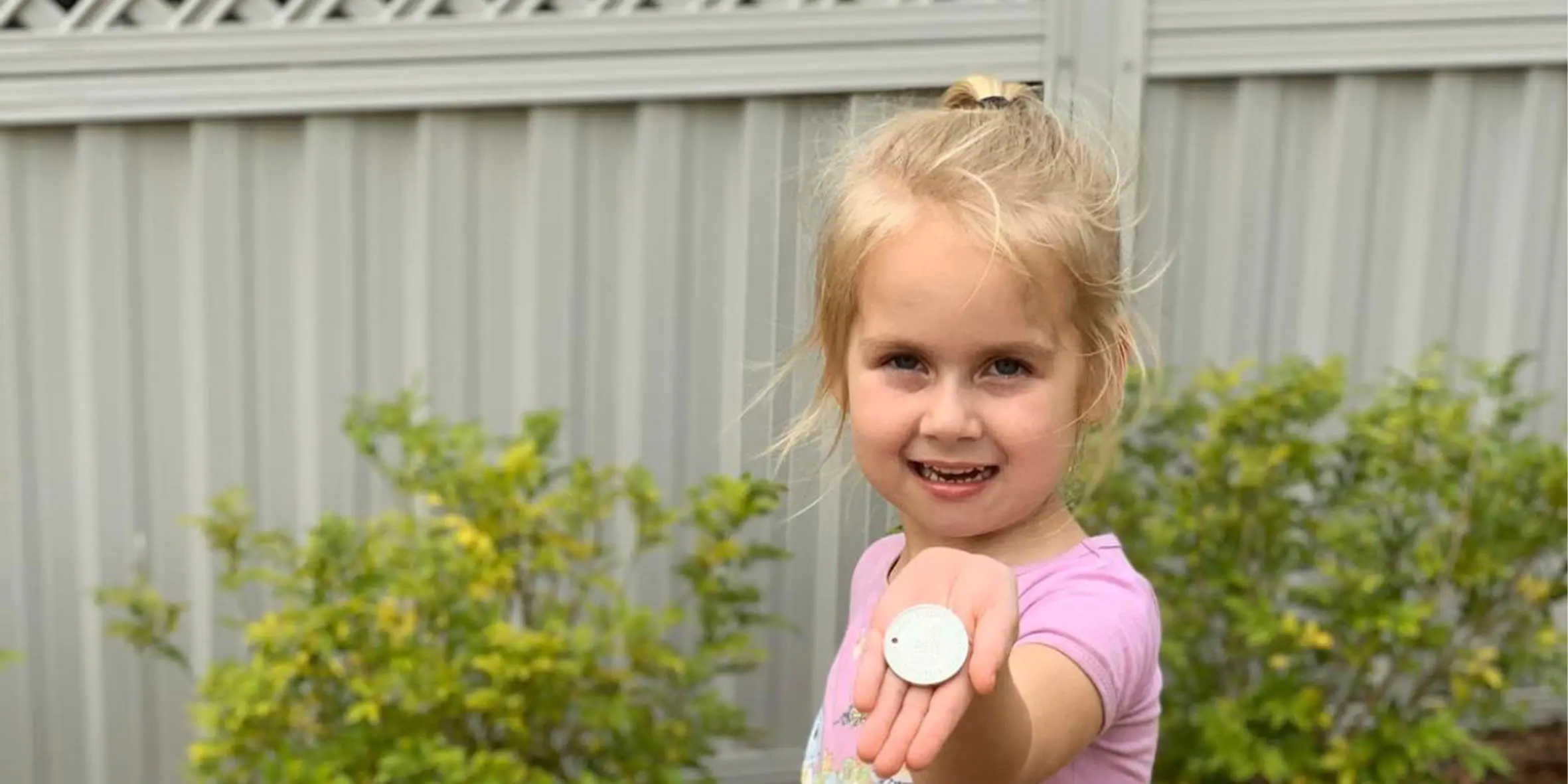 Make-A-Wish kid Penelope holds her wish coin ahead of her wish day