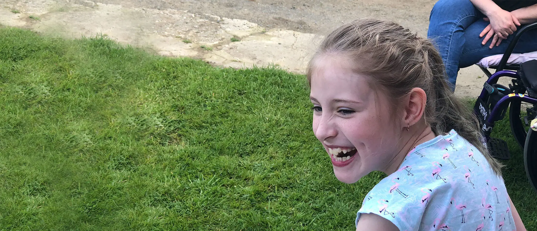 Make-A-Wish Australia wish kid Grace sat smiling in the garden